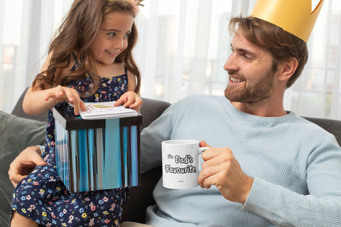 Family Mugs with Zimbabwean Words - Dad holding a white mug that says "I'm Dad's Favourite" sitting next to his daughter who is excited about opning her birthday gift. They are wearing party hats